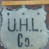 c84db574-f1e0-4969-b4af-f5547d4586e0-scaled-1.jpg Antique UHL Co. Metal Shield Sign Industrial Advertising Highway Marker Vtg tin!